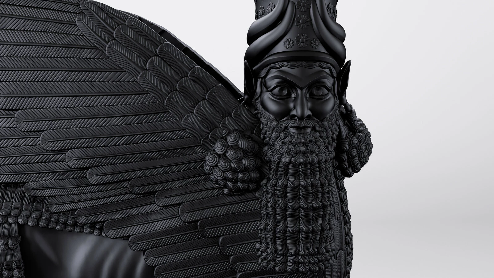 A dark sculpture of a winged deity with a long beard.