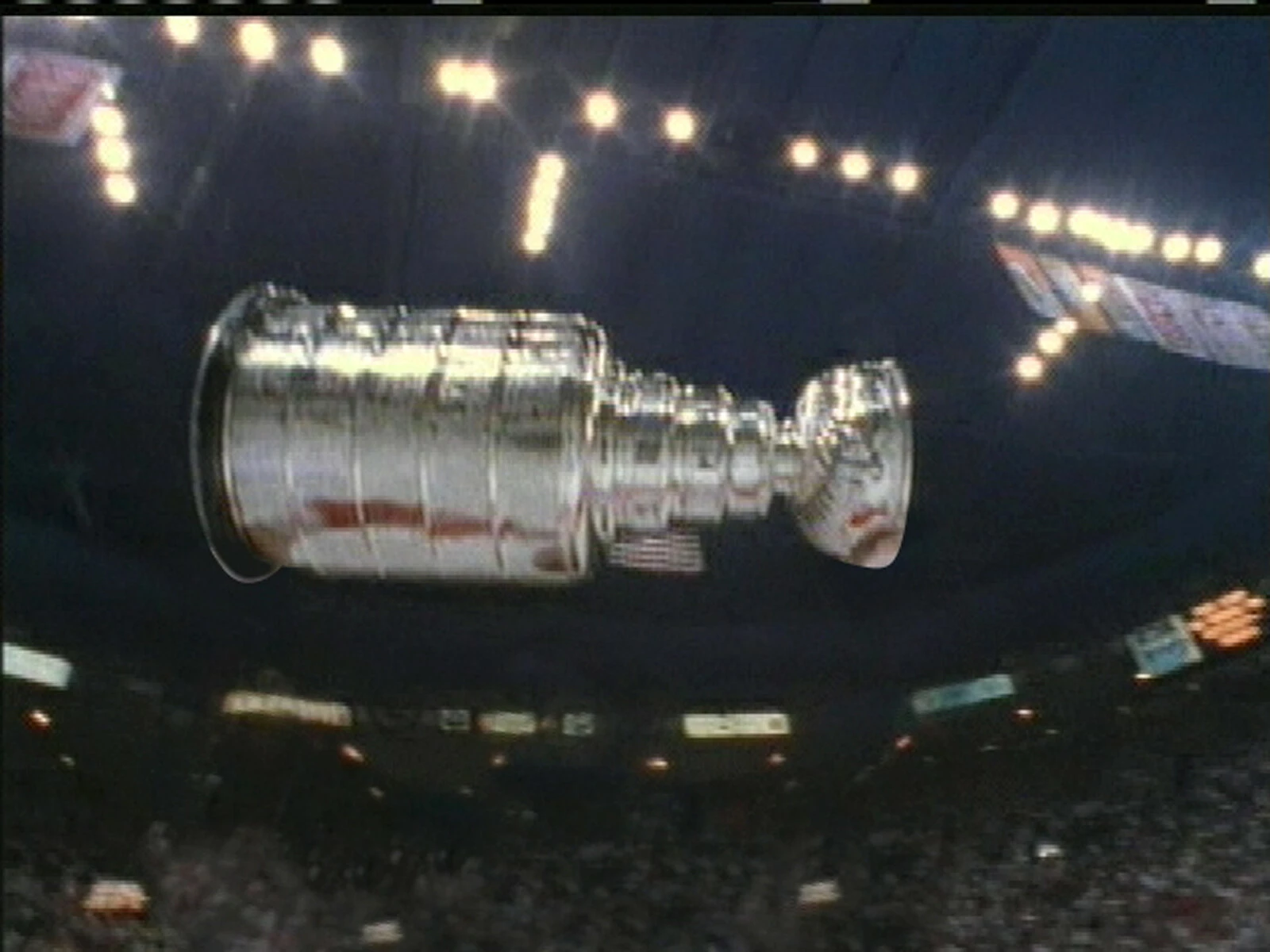 The Stanley Cup floating in the middle of an arena filled with lights