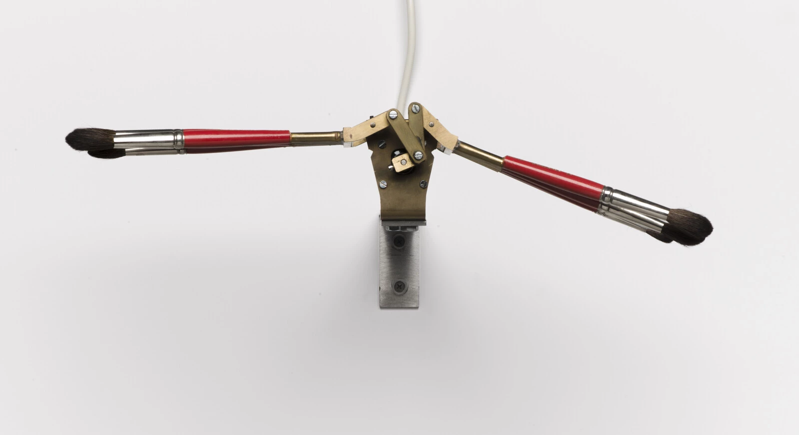 An electronic contraption holding three paintbrushes on each side giving the illusion of wings